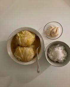 two bowls filled with food next to some rice