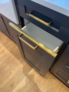 an image of a kitchen drawer with gold handles and drawers on the bottom half of it