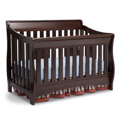 a wooden crib with blue bedding and pillows on the bottom row, against a white background