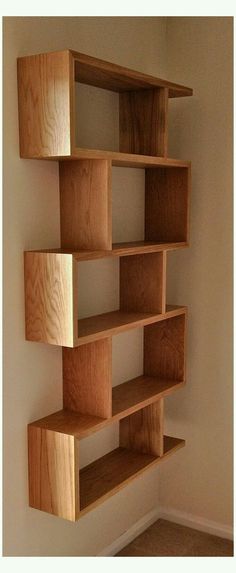 a wooden book shelf in the corner of a room