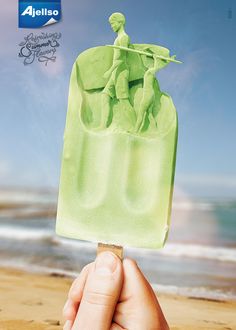 a hand holding an ice lolly popsicle with the image of two people on it