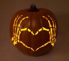 a carved pumpkin with the shape of a heart on it's face and hands