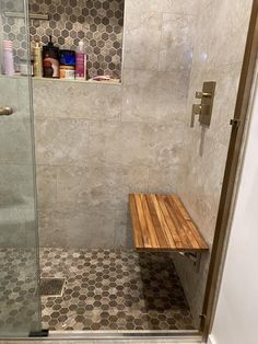 a shower with a wooden bench in it