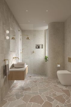 a modern bathroom with stone flooring and walls