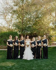 a group of women standing next to each other on top of a lush green field