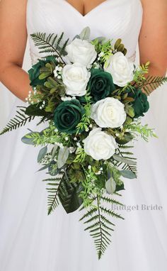 a bride holding a bouquet of white and green flowers