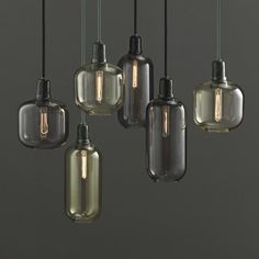 an assortment of glass pendant lights hanging from a ceiling in a kitchen or dining room