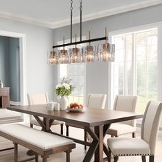 a dining room table with white chairs and a chandelier