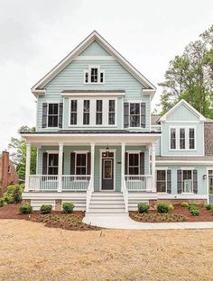 a large blue house with white trim and two story windows on the second floor is shown