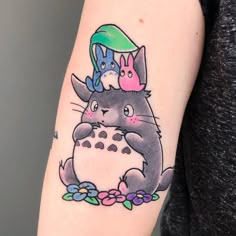 a woman with a tattoo on her arm has a totoro and an owl