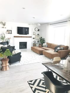 a living room filled with furniture and a flat screen tv mounted on the wall above a fireplace