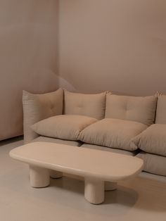 a white couch sitting next to a coffee table in a living room with beige walls