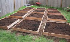 several wooden boxes filled with dirt in the yard