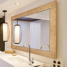 a bathroom with a sink, mirror and hanging light fixture in it's center