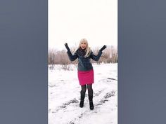 a woman is standing in the snow with her hands up and arms out to the side