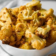 a white bowl filled with cauliflower on top of a table