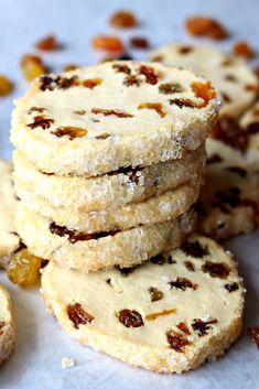 a stack of cookies sitting on top of a white paper covered in raisins