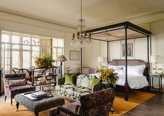 a living room filled with furniture and a chandelier hanging over it's head