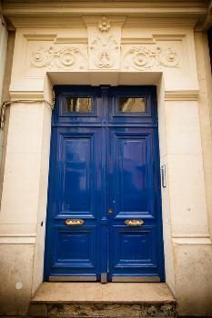 two blue doors in front of an old building