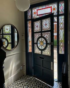 an entryway with stained glass and black door