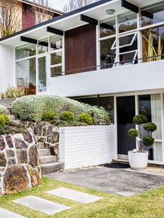 a modern house with stone steps leading up to the front door