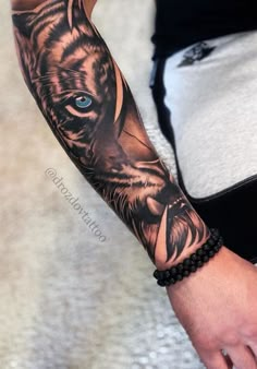 a man's arm with a tiger tattoo on it, and blue eyes in the center