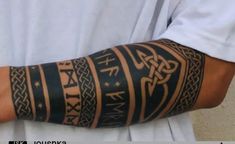 a man's arm covered in black and brown tattoos with different designs on it