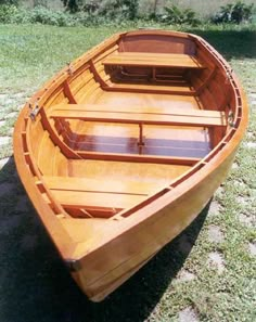 a small wooden boat sitting on the grass