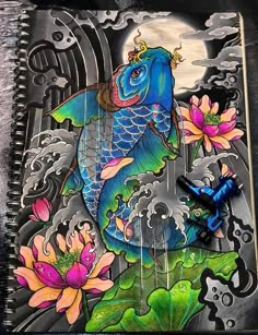 a notebook with an image of a fish in the water and flowers on top of it