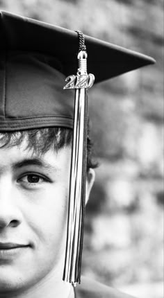 a young man wearing a graduation cap and gown with a tassel on his head