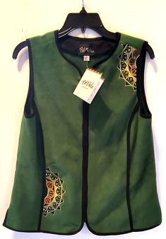 Bob Mackie Wearable Art Vest Add a unique and stylish touch to your casual outfit with this Bob Mackie Wearable Art Vest in size S. The green vest features an embroidered design that will surely catch the eye. The mid-length vest has a sleeveless cut and a full zip closure for a comfortable fit. Made with fleece fabric, this vest is perfect for all seasons, whether it's winter, summer, fall, or spring. This vest is a rare and unique piece that will surely impress. It has a regular fit, making it suitable for women of all sizes. The vest is not only fashionable but also practical, featuring outer shell material of unknown origin. This vest is a must-have addition to your wardrobe. Inquiries Welcome ~ Satisfaction Guaranteed ~ Thanks for Looking! Green Casual Vest For Fall, Casual Green Vest For Fall, Fall Cotton Embroidered Vest, Fall Embroidered Cotton Vest, Casual Embroidered Sleeveless Vest, Green Vest Top For Fall, Green Sleeveless Vest With Patchwork, Green Sleeveless Patchwork Vest, Green Patchwork Vest For Spring