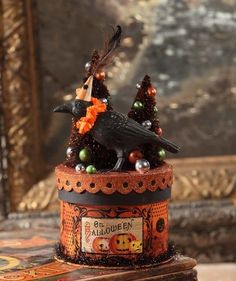 a black bird sitting on top of a wooden box filled with candy and candies