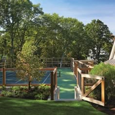 an outdoor tennis court surrounded by trees and grass