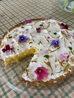 a pie with white frosting and purple flowers on it