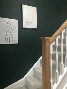 the stairs are painted green and white with pictures on the wall above them, along with artwork