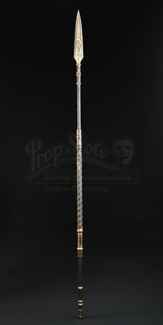 a large metal pole with an ornate design on the top and bottom, standing in front of a black background