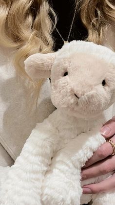 a woman holding a white stuffed animal in her hands