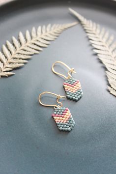 two pairs of beaded earrings sitting on top of a plate