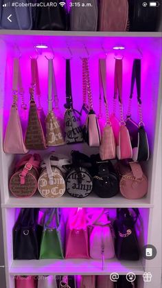 a shelf filled with lots of purses on top of each other in front of a purple light