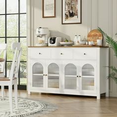 a white dining room table and chairs in front of a window