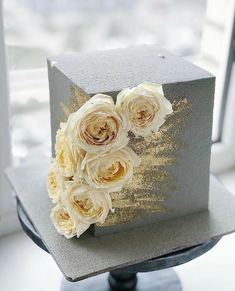 there is a cake that has flowers on the top of it and some gold foil