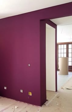 an empty room with purple walls and white trim