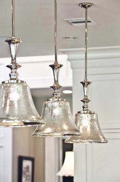 three lights hanging from a ceiling in a kitchen