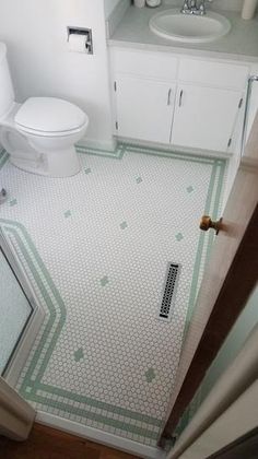 a white toilet sitting next to a sink in a bathroom