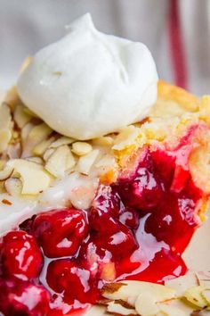 a piece of pie with cherries and whipped cream on top