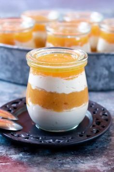 small desserts with orange and white frosting in glass jars