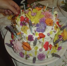 a white cake topped with lots of colorful flowers