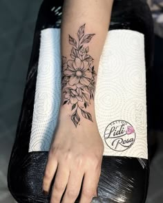 a woman's foot with a flower tattoo on it