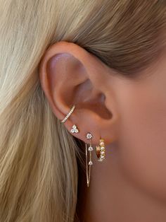 a woman's ear with three different types of piercings