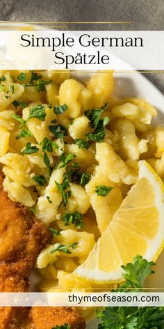 a white plate topped with macaroni and cheese next to lemon wedges